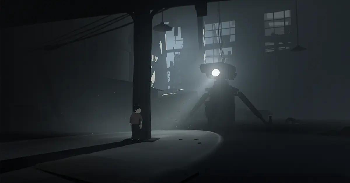 The protagonist of INSIDE standing in a dark, atmospheric facility.